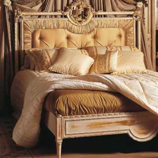 Classic bed with capitonné headboard and handmade carvings. White over gold finish. Louvre classic luxury furniture collection