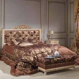 Bed with capitonné headbord and rich carvings handmade in Italy, laquered with gold details as the night tables. Capitonné bench